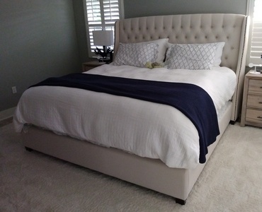 King size soft biege bed in bedroom.