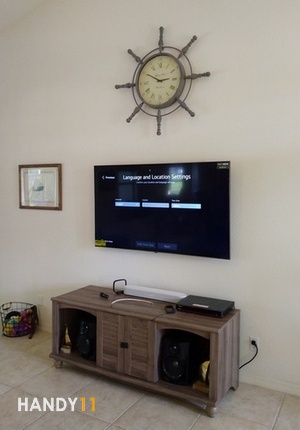 Clock, TV, Art on the wall. TV stand on the floor. Handyman services.