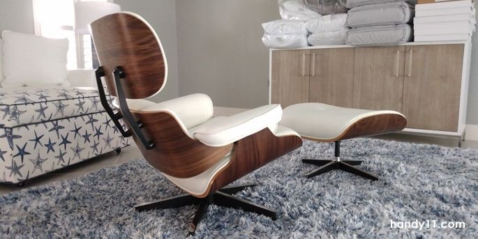 Wood and white leather chair and ottoman in living room.