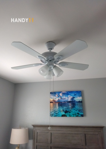 Ceiling fan installed and art hanged on the wall.