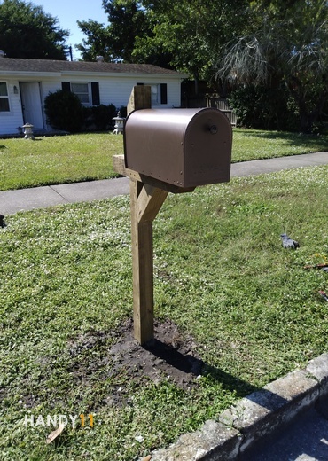 Brown wood mail post in the ground.