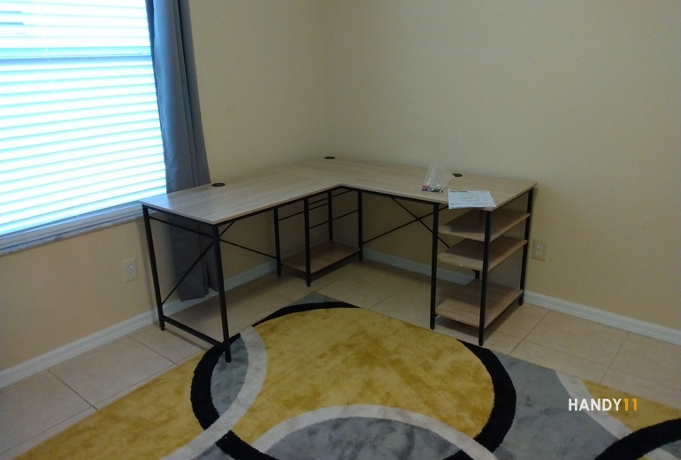 L-Shape office desk, yellow-grey rug.