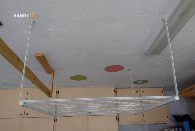 Ceiling mounted white metal garage shelves.