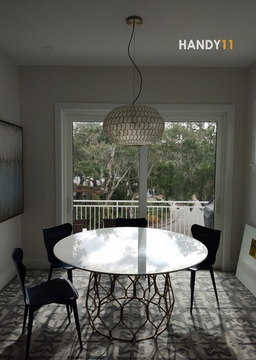 Light fixture and glass round table in dining area.