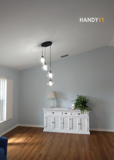 Wired light fixture and white wood cabinet.