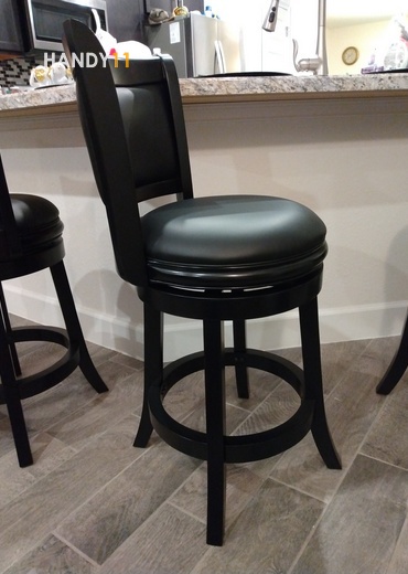 Black leather round seat bar stool at the bar.