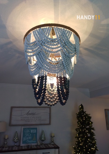 Blue and Brown Wood pearls chandelier and Christmas tree in living room.