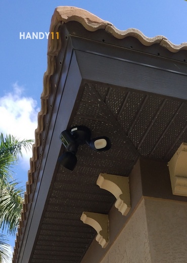 Wired security camera installed on house corner.